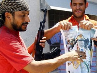 Повстанцы рвут портрет с изображением Муаммара Каддафи на территории его резиденции Баб эль-Азизия